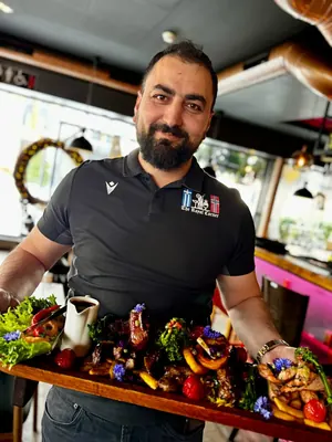 Inhaber präsentiert eine Grillplatte